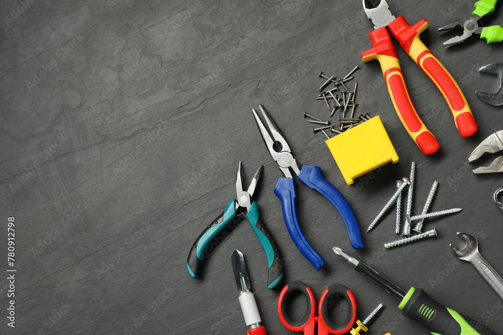 Poster Different pliers, screwdriver, wrenches and other repair tools on black textured table, flat lay. Space for text