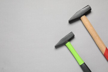 Two hammers on grey background, top view. Space for text