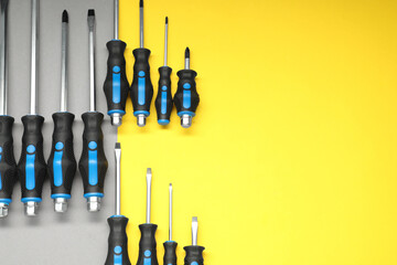 Set of screwdrivers on color background, flat lay. Space for text