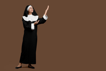 Portrait of young nun on brown background