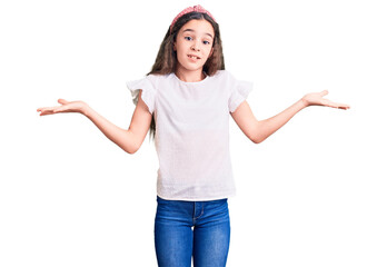 Cute hispanic child girl wearing casual white tshirt clueless and confused expression with arms and hands raised. doubt concept.
