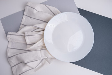 White empty plates and cutlery on a napkin on a white table. Top view of an empty dish. Banner for...