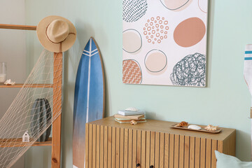Interior of light room with shelving unit, surfboard and picture