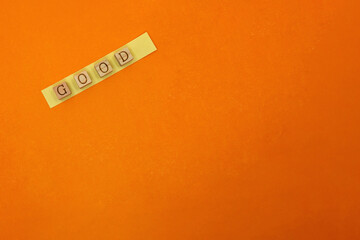 GOODの英単語がのった付箋が左斜めにはられているオレンジ色の背景