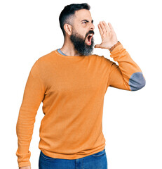 Hispanic man with beard wearing casual winter sweater shouting and screaming loud to side with hand...