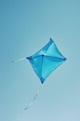 A blue kite flying in the clear blue sky. Perfect for outdoor activities