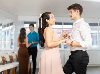 Elegant couple performs an expressive latin american dancing in bright, modern dance studio during...