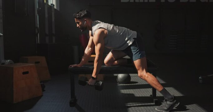 Music, dumbbell and man workout in gym for muscle, wellness and body health. Earphones, weightlifting and strong bodybuilder training for fitness, serious and listening to audio for exercise in club