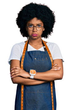 Young african american woman dressmaker designer wearing atelier apron depressed and worry for distress, crying angry and afraid. sad expression.