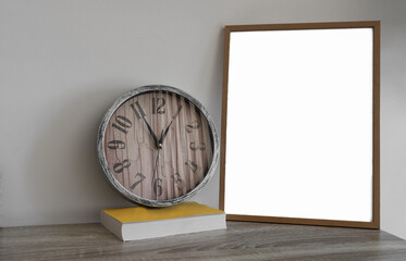 blank mockup frame. home desk with yellow book, round watch and mock up wooden frame. template for photo image, picture. white wall on background. empty copy space for inscription. interior front view