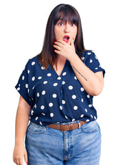 Young plus size woman wearing casual clothes looking fascinated with disbelief, surprise and amazed expression with hands on chin