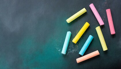 Colored pieces of chalk on a black board or chalkboard. Background for teaching, education or school class applications.