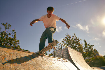 Young active skateboarder flies with his board on the ramp of a skate park