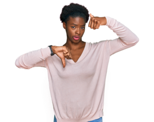Young african american girl wearing casual clothes doing thumbs up and down, disagreement and agreement expression. crazy conflict