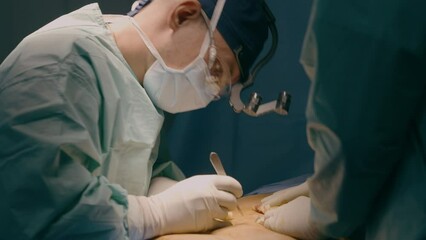 Two doctors operating patient in clinic hospital surgeon man medic physician perform surgical operation cesarean section abdominal plastic surgery cut stomach abdomen with scalpel medicine health care