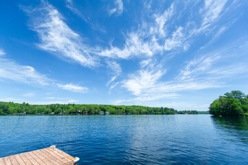 A tranquil lakeside scene unfolds, with quaint cottages nestled amidst lush greenery on the...