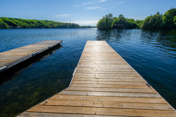 Calm lakefront with wooden docks at a Muskoka cottage in Canada.