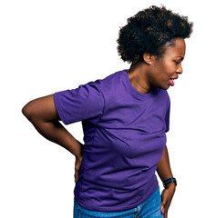 African american woman with afro hair wearing casual purple t shirt suffering of backache, touching...
