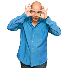 Middle age bald man wearing casual clothes trying to open eyes with fingers, sleepy and tired for...