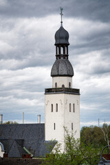 Tower of the former Schifferkirche St. Clemens from the 12th century in cologne mülheim in front of a gloomy cloudy sky