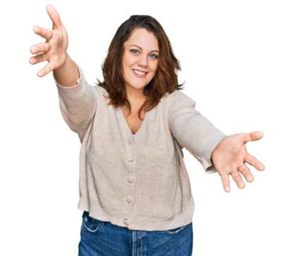 Young plus size woman wearing casual clothes looking at the camera smiling with open arms for hug. cheerful expression embracing happiness.