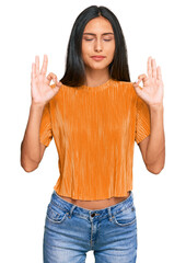 Young brunette arab woman wearing casual clothes relax and smiling with eyes closed doing meditation gesture with fingers. yoga concept.