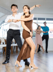 Energy young man paired girl and dancing classic version of waltz in couple during lesson. Leisure...