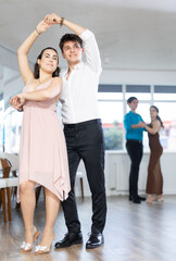Fototapeta premium Young man and young woman dance ballroom dance waltz in studio