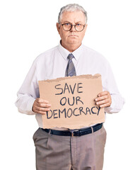 Senior grey-haired man wearing business clothes holding save our democracy protest banner thinking...