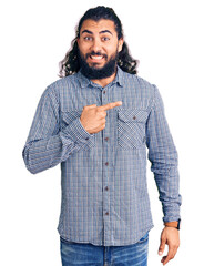 Young arab man wearing casual clothes pointing aside worried and nervous with forefinger, concerned...