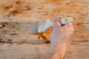  hand paints wooden boards with oil.Oil and varnish for wood. Impregnation of a wood with...