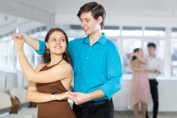 Young couples learning to dance latin american dances in a dance studio