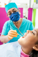 Mexican Female Receiving a Dental Check-Up, Leaning Back in the Chair