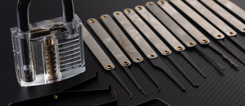 Clear Lock device over black background to show mechanic inside lock. Many lock pick tool to unlock key of door window vehicle for thief lockpick burglar.