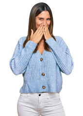 Young woman wearing casual clothes laughing and embarrassed giggle covering mouth with hands,...