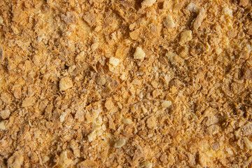 Backing process. Closeup of Puff pastry layers of the delicious French Napoleon cake laying on the backing paper. French pastry with custard butter cream. Side view. Selective focus. - obrazy, fototapety, plakaty