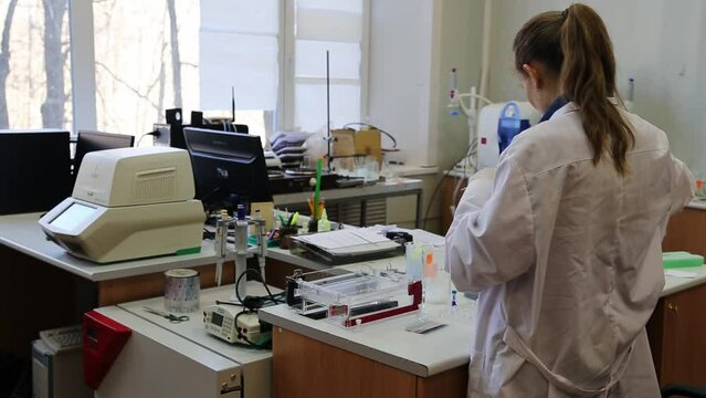 Scientist puts samples with DNA fragments into agarose gel for separation of DNA fragments for electrophoresis