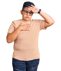 Little boy kid wearing casual clothes and glasses touching forehead for illness and fever, flu and cold, virus sick