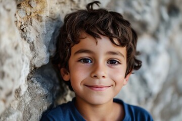 Portrait of a little boy on a background of a stone wall