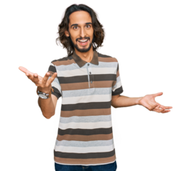 Young hispanic man wearing casual clothes smiling cheerful with open arms as friendly welcome, positive and confident greetings