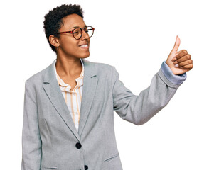Young african american woman wearing business clothes looking proud, smiling doing thumbs up...