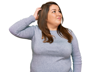 Beautiful brunette plus size woman wearing casual clothes confuse and wondering about question. uncertain with doubt, thinking with hand on head. pensive concept.