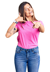 Beautiful caucasian woman wearing casual clothes smiling doing talking on the telephone gesture and...