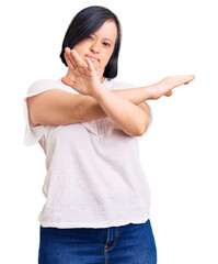 Brunette woman with down syndrome wearing casual white tshirt rejection expression crossing arms and palms doing negative sign, angry face