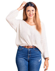 Fototapeta premium Beautiful young woman wearing casual clothes confuse and wonder about question. uncertain with doubt, thinking with hand on head. pensive concept.