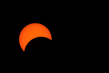 The solar eclipse on April 8, 2024 before totality. Sunspots are visible, and about a third of the sun is blocked.