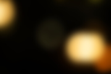 A blurry image of a dark background with a yellow light in the center