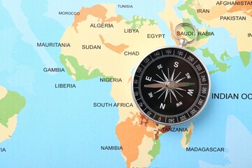 One compass on world map, top view. Space for text