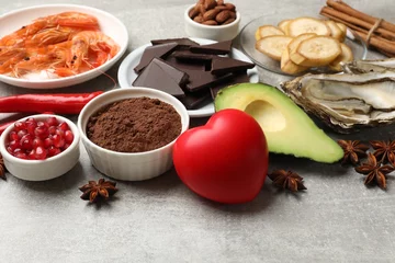  Natural aphrodisiac. Different food products and heart model on grey table, closeup © New Africa