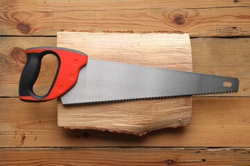 Saw with colorful handle and log on wooden background, top view